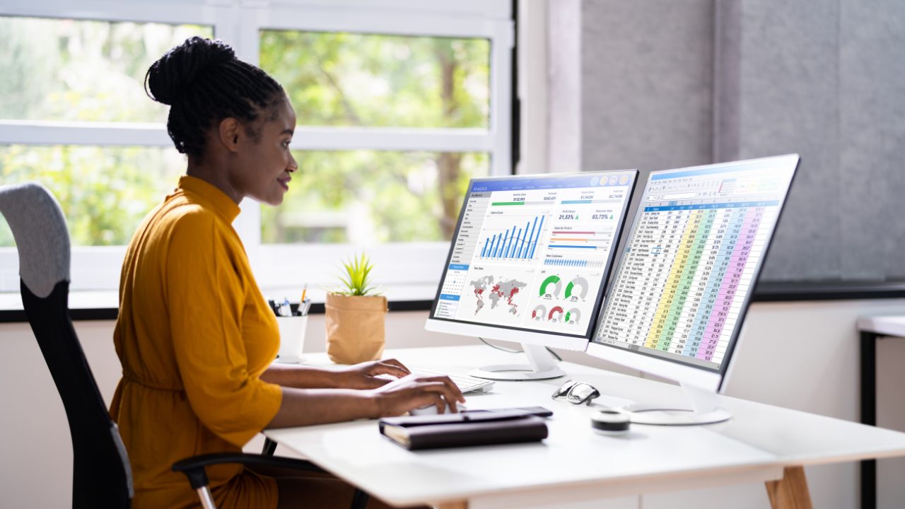 Women in front of laptop with spreadsheets.